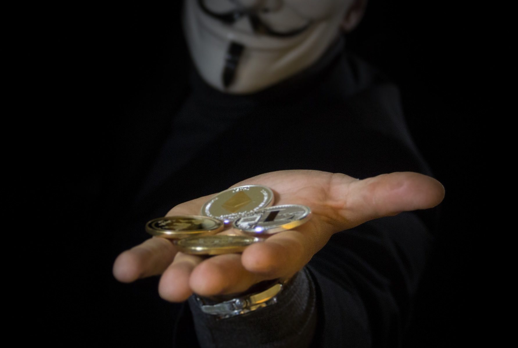 'anonymous" character holding bitcoins in hand