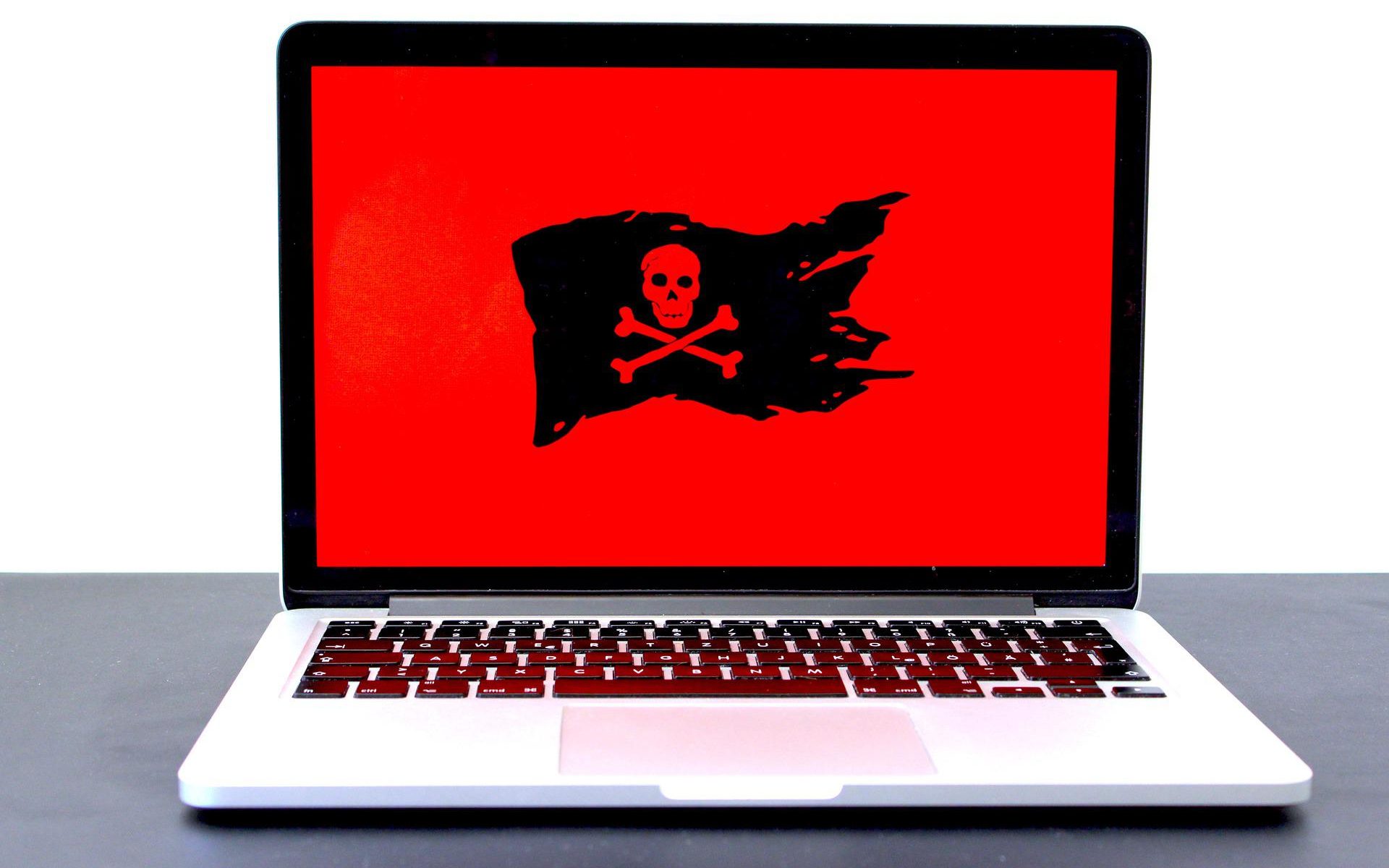 laptop with red screen and a black pirate flag