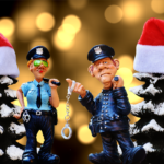 Claymation police in front of two Christmas trees with Santa hats.