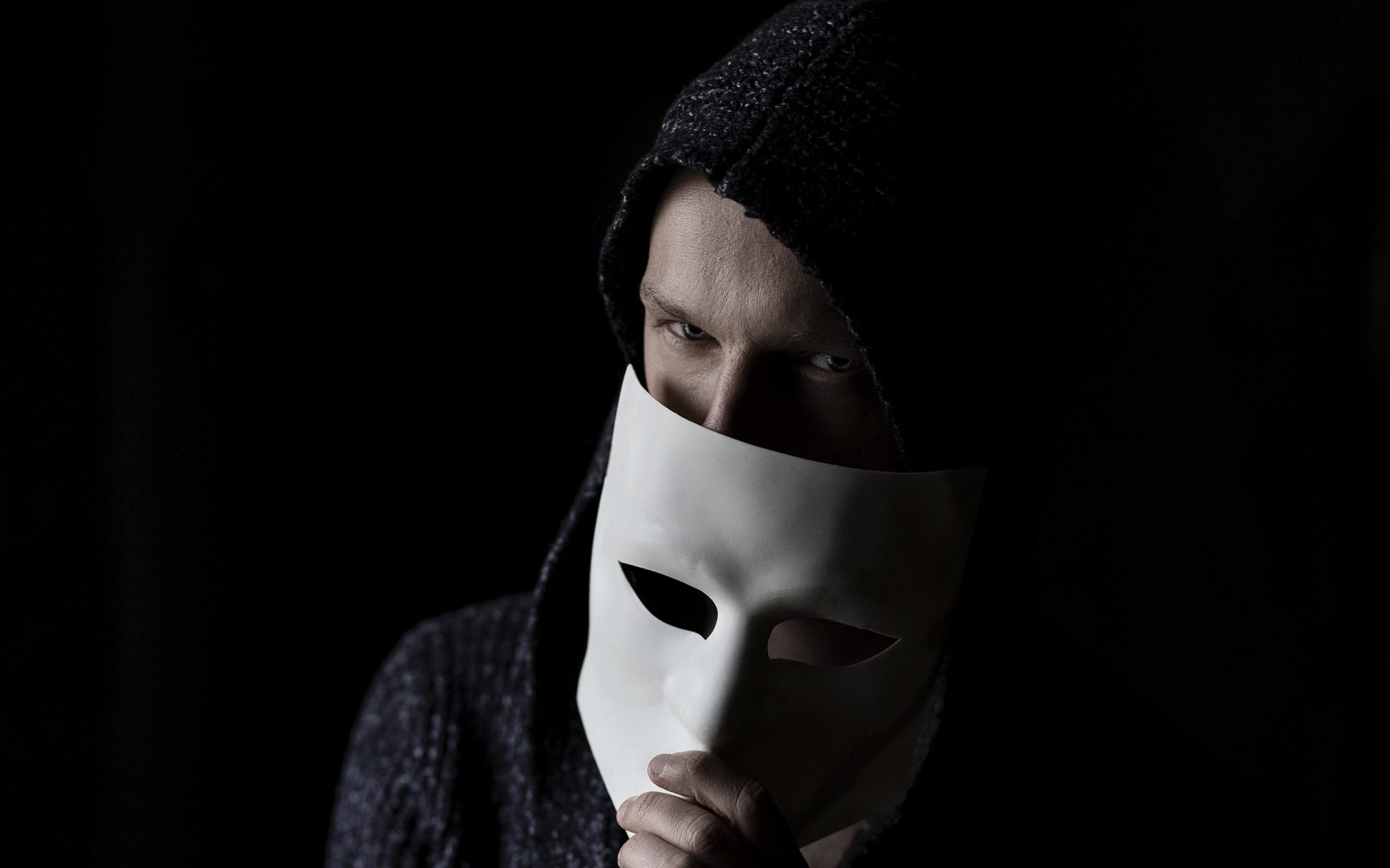 cybercriminal hiding half his face with a mask