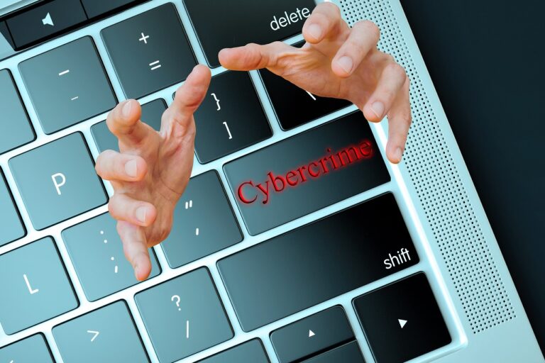 Keyboard with "Cybercrime" in red on one key and hands coming from the key