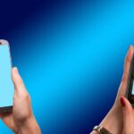 two people texting with cell phones