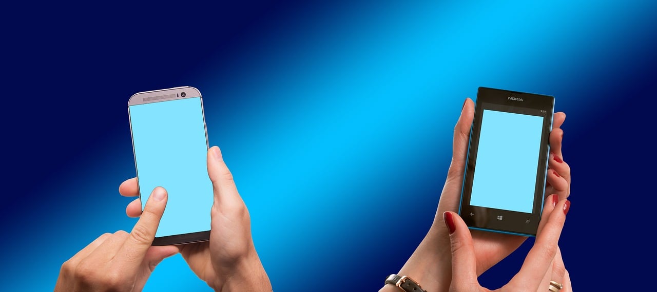 two people texting with cell phones